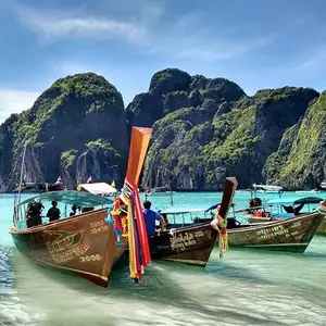 Thailand travel banner featuring a tropical beach with turquoise water and boats. Text: Thailand tickets starting at just ₹34,499.