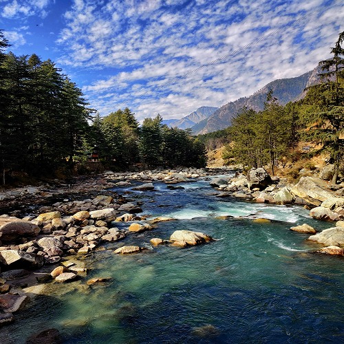 Mountain landscape of Kasol and Parvati Valley, promoting backpacker hostels, trekking, and cafe hopping.